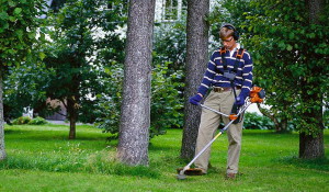 325Rxt-series, Man trimming round trees in garden with house in background, consumer, trimmer head, Henrik Ottoson